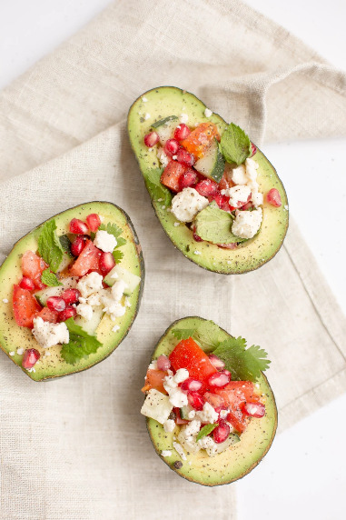 Healthy and tasty stuffed avocados with tomatoes and cheese.